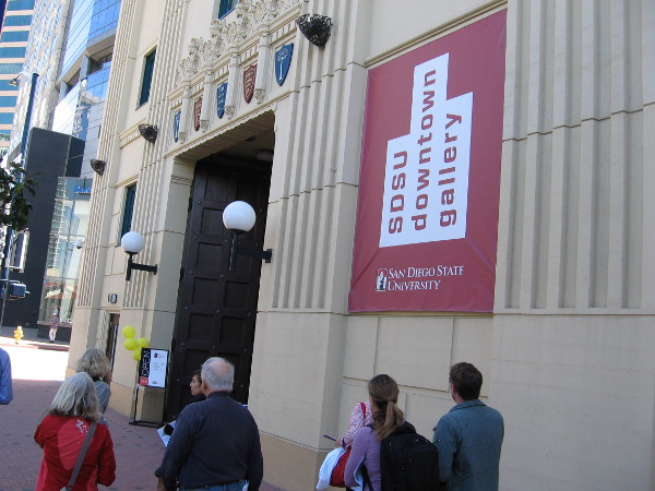 People walk along Broadway near the entrance of the SDSU Downtown Gallery.