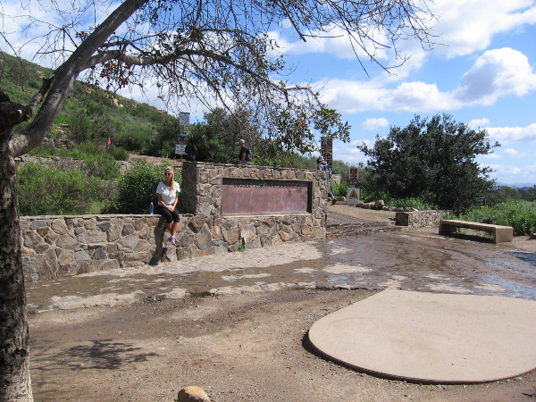 Someone sits on the stone wall at the Cowles Staging Area. This is one of the most popular hiking trails in San Diego, and can be somewhat crowded on weekends.