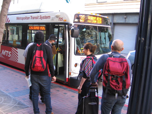 People board an MTS bus near the Fifth Avenue trolley station.