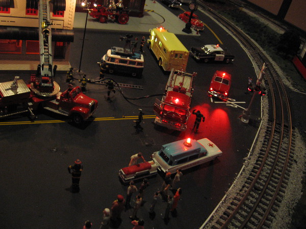 A detailed scene recreates firemen fighting a fire at night.
