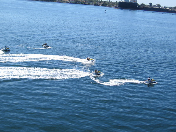 Five people were jetting around the bay on some fun personal watercraft.