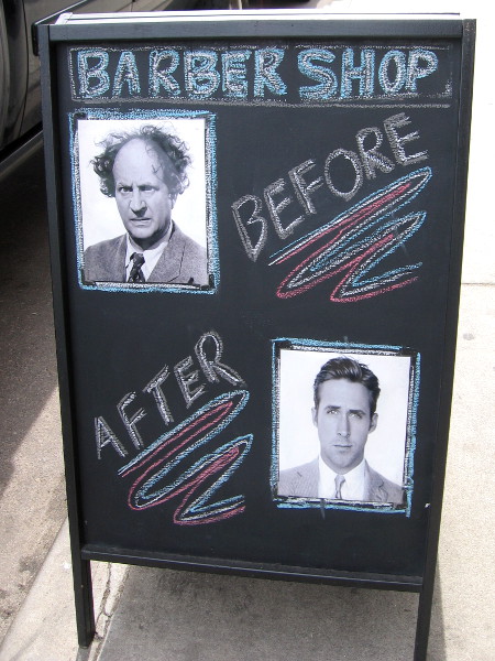 A humorous sign on the sidewalk. Head into this barber shop and come out a completely different person!