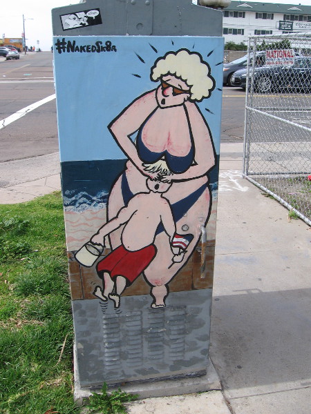 A very funny utility box. This side shows a woman at the beach covering the eyes of a small boy.
