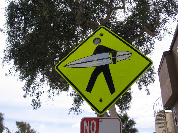 A traffic sign warns of surfers crossing!