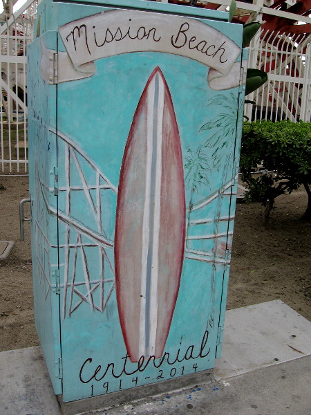 Street art celebrates the Mission Beach Centennial, 1914-2014. The Giant Dipper roller coaster, the main attraction of Belmont Park, is in both the artwork and the photograph's background.