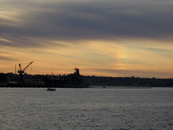 A slight rainbow appears at sunset above Point Loma.