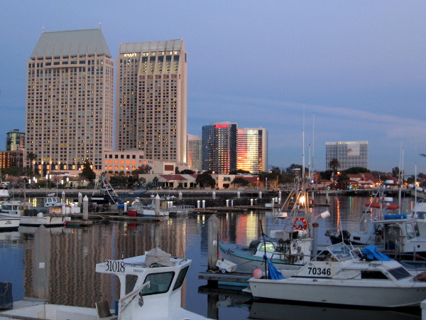 Sunset's bright red and yellow reflects from the silvery Marriott Marquis, and onto the calm water of Tuna Harbor.