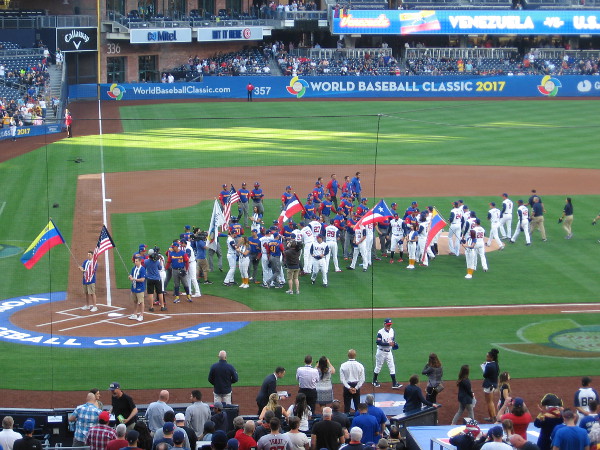 The players for the United States and Venezuela shake hands at the end of the opening ceremony.