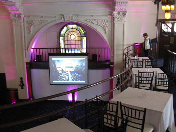 These tables along the second floor overlook a large space where people might dance or mingle during a special event.