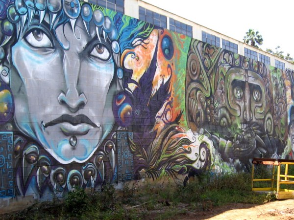 Bold faces peer from a wall in one alley on National Avenue.