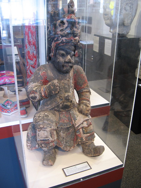 A temple guardian, from Ming Dynasty. The carved wooden idol has a dragon headdress, robes, glass eyes and a real hear beard and mustache.