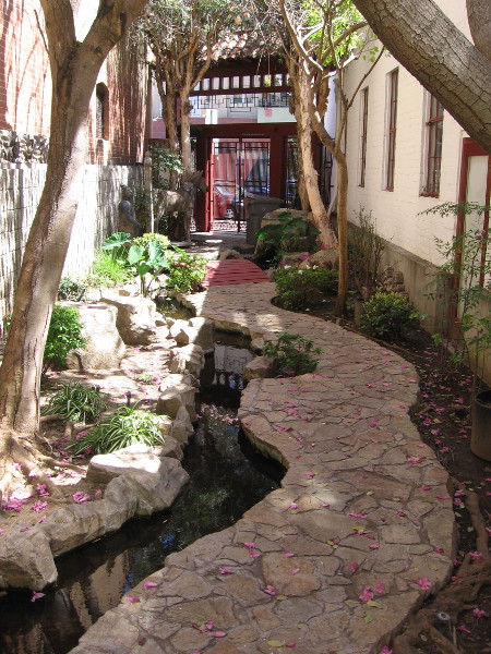A tranquil path runs beside water along the north side of the San Diego Chinese Historical Museum.