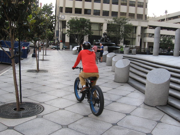 Someone rides a bicycle along B Street during San Diego's Bike to Work Day.