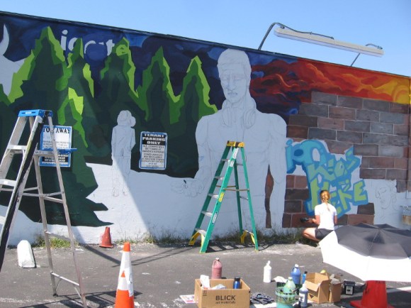 Ion Theatre artist Kate Schott paints a cool mural on a wall in Hillcrest.