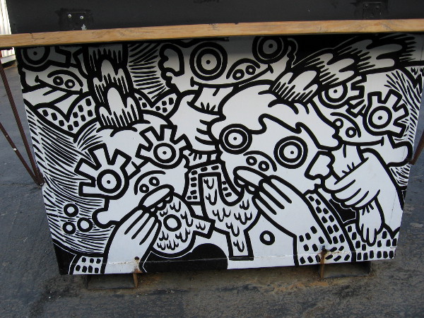 Several planters have their sides painted with whimsical faces. These are eating food-like letters and pulling tongues.