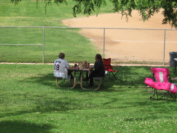 Someone in a Gwynn San Diego Padres jersey sits by the softball field at Lake Poway, not far from the statue.