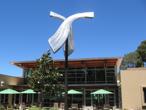 A shining, kinetic sculpture by the library turns in the breeze.