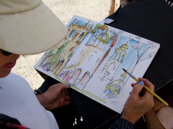 Michelle Gonzalez of Spanish Village was sitting in the Plaza de Panama painting three of Balboa Park's landmark towers: the iconic California Tower and towers from the House of Hospitality and the House of Charm.