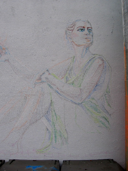 A third figure on the left side of the developing mural. Many colors outline the sitting figure of a woman.