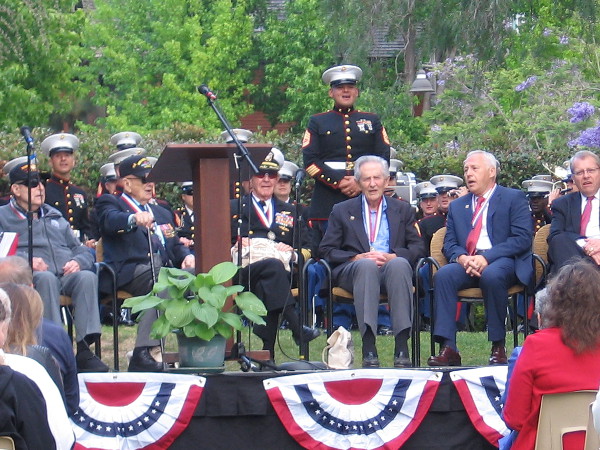 Many voices sing God Bless America.