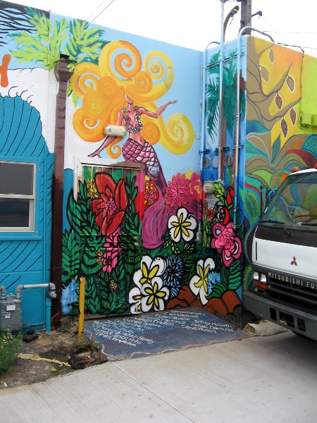 Swirling, blooming beauty painted in a nook. A mermaid is perched above flowers.