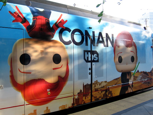Conan is hanging upside down from the roof of the trolley. He is your friendly neighborhood Spiderman!