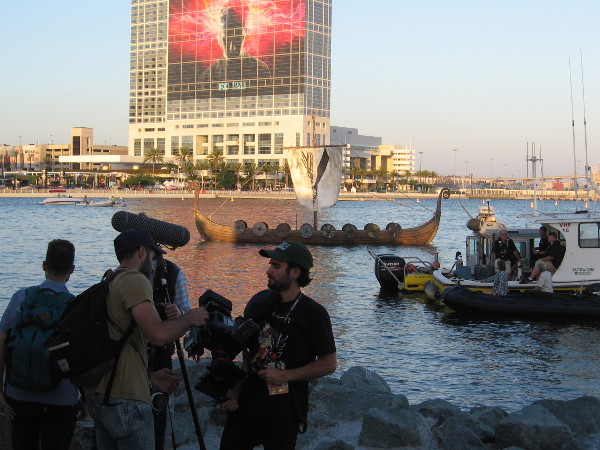 The Viking longship is overtaken by shadow as the sun sets, then finally the nearby boats move safely away.