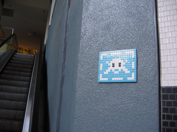 A space invader made of tile near a Horton Plaza escalator!