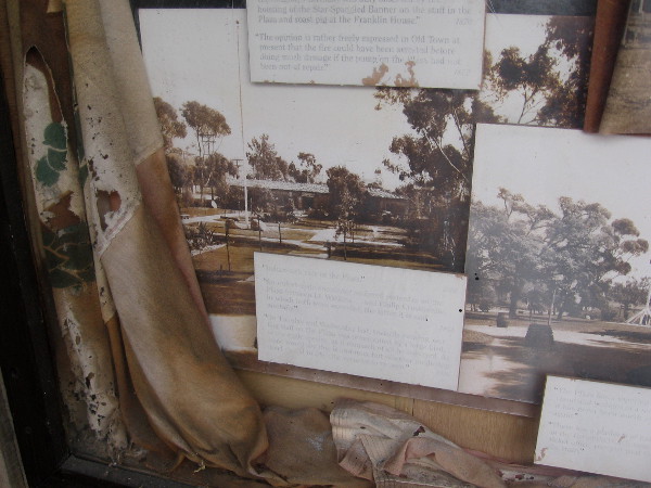 Decayed flag and old photos of tall flagpole at center of La Plaza de Las Armas.