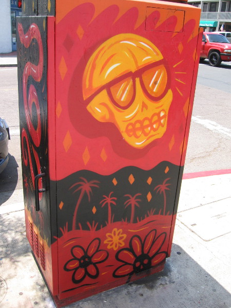 A skull above palm trees and flowers.