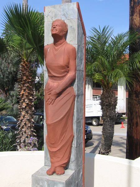 Graceful female figure sculpted with lifted head and smile.