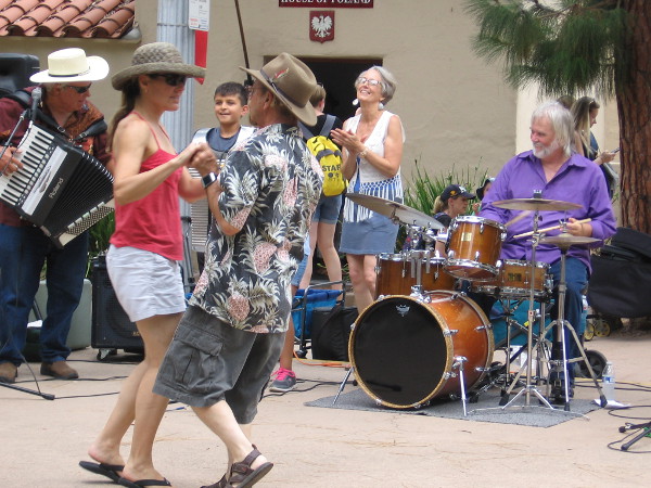 Folks dance on the stage at the center of Balboa Park's International Cottages. The lawn program today was hosted by the House of France.