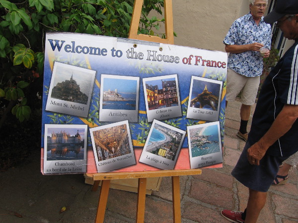 A poster says Welcome to the House of France. It depicts Mont St. Michel, Château de Versailles, la Tour Eiffel, and other popular national attractions.