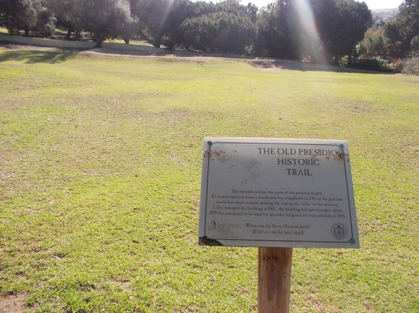 Sign marks the Old Presidio Historic Trail. Grassy mounds on the hill below the Serra Museum are the ruins of the old presidio chapel.