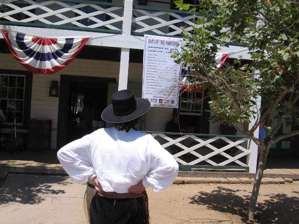 Someone reads Days of the Vaqueros sign on the Robinson Rose House in Old Town San Diego State Historic Park.