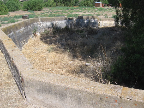 An octagonal concrete reservoir to the north, uphill from the ranch house. Photographic evidence shows water might have been pumped up here by windmill.