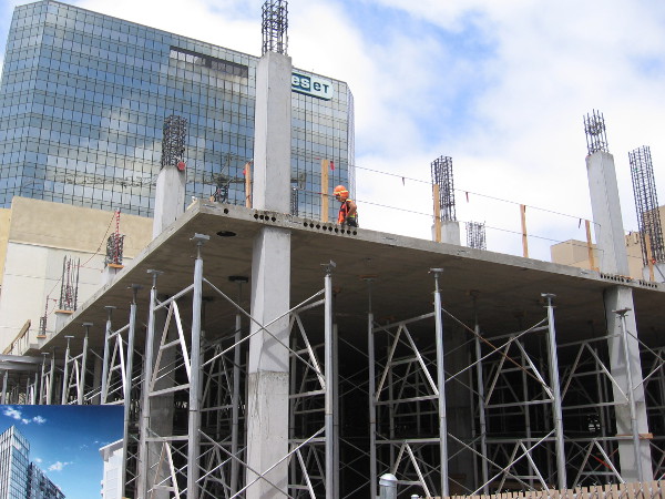 Construction worker atop the rising luxury apartment building.