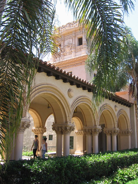 People walk past ornate arches connecting the Casa de Balboa and the House of Hospitality.