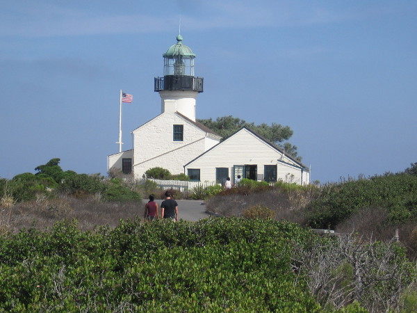 People approach the handsome lighthouse from the south.