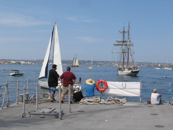 People watch as the Irving Johnson heads out to face the Spirit of Dana Point in a cannon battle on San Diego Bay.