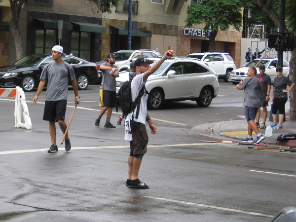 Cars head down the nearby street as a game is in progress. It rained a little bit today, as you can see.