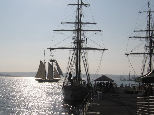The final day at the Festival of Sail is almost over. The masts and yards of the docked brigantine appear bare.