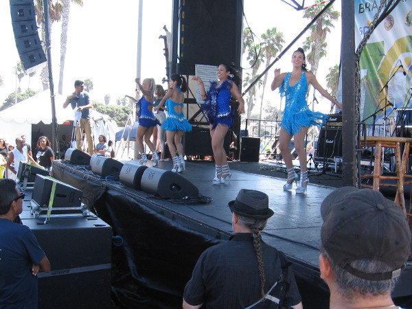 Smiling ladies commenced an energetic dance routine on the stage to the delight of the growing crowd.