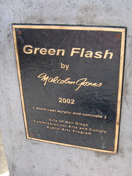 A plaque describes the unusual public artwork. Green Flash by Malcolm Jones, 2002. Solid cast acrylic and concrete.