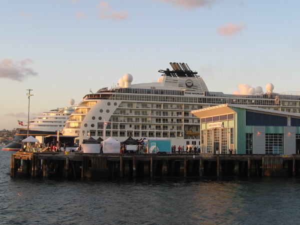 A photo of The World and Disney Wonder as sunset approaches in San Diego.