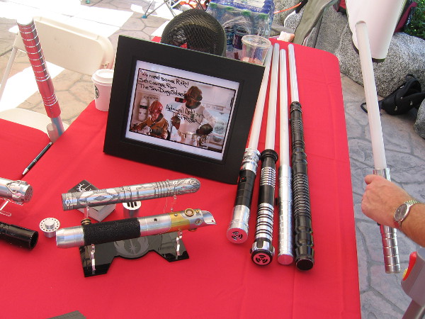 Someone picks up one of the cool lightsabers on display.