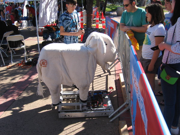 People at San Diego's annual Maker Faire in Balboa Park check out a very creative robot designed by a friendly young man.