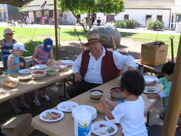 Kids at the Old Town Fall Festival learn to make art with colored beans!