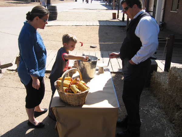 Kid learns how to plant seeds in front of the Wells Fargo History Museum.