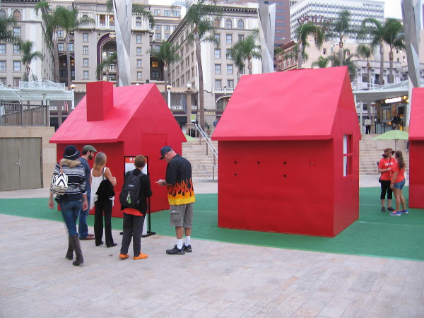 People pause to read a sign that describes some very unique and thought-provoking performance art that can be enjoyed freely by anyone passing by.